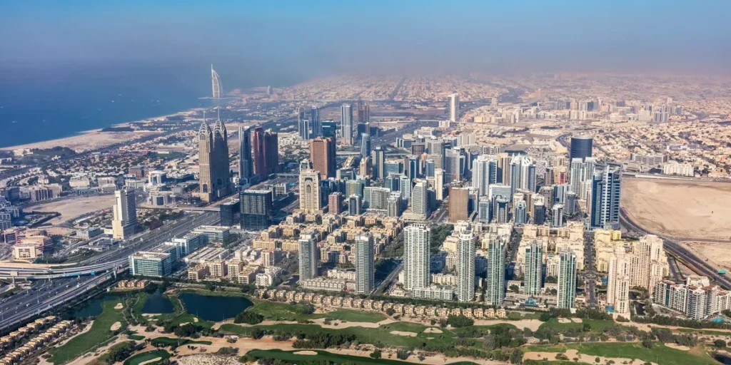 Dubai city aerial with Emirates Hills golf course Burj Al Arab and SZR corridor real photo — Dubai freehold properties for foreigners