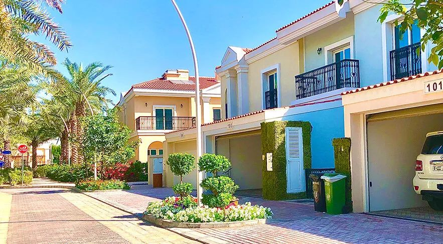 Palm Jumeirah Mediterranean style villas with garden frontages and palm-lined street real photo — Dubai investment properties